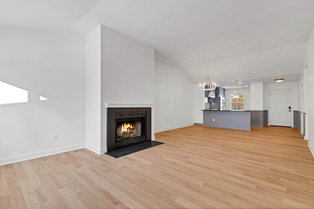 unfurnished living room with a chandelier and light wood-type flooring