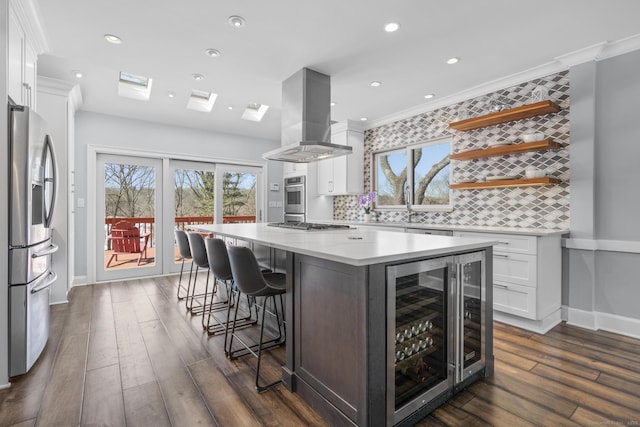 kitchen featuring wine cooler, open shelves, light countertops, white cabinetry, and island range hood