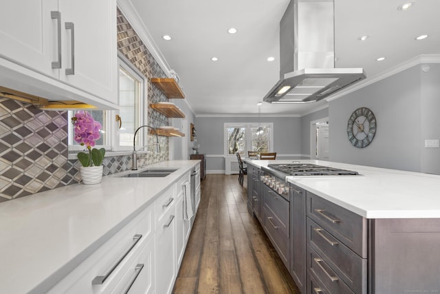 kitchen with white cabinets, island exhaust hood, stainless steel gas cooktop, open shelves, and a sink