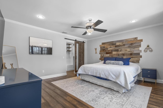 bedroom featuring dark wood-style floors, a barn door, and ornamental molding