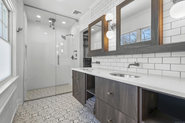 full bath featuring visible vents, ornamental molding, decorative backsplash, and a sink