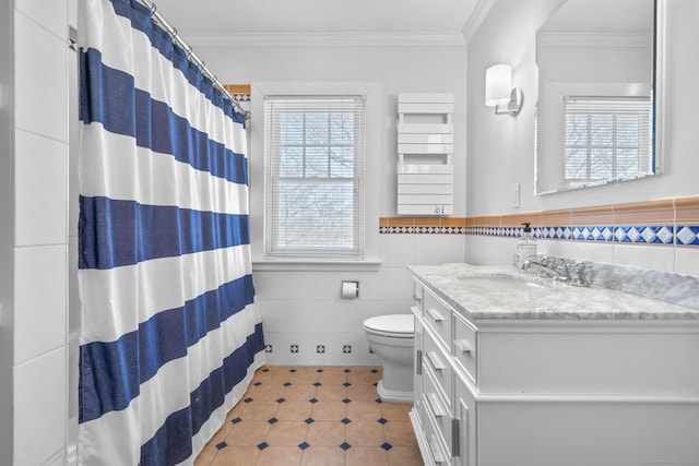 full bathroom with vanity, tile walls, wainscoting, a shower with curtain, and crown molding