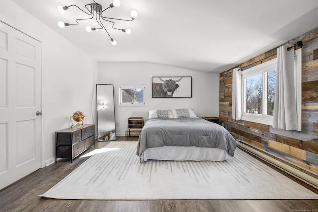 bedroom with lofted ceiling, dark wood-style floors, and an inviting chandelier