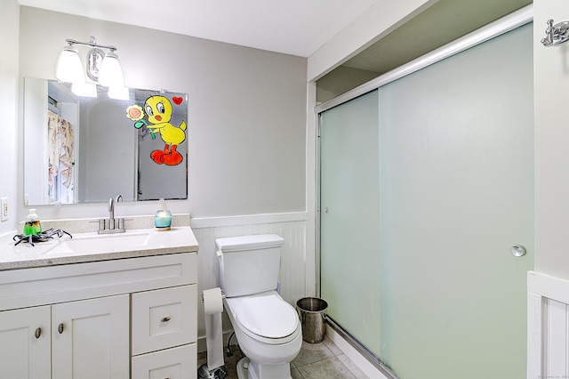 bathroom featuring vanity, toilet, an enclosed shower, and tile patterned flooring