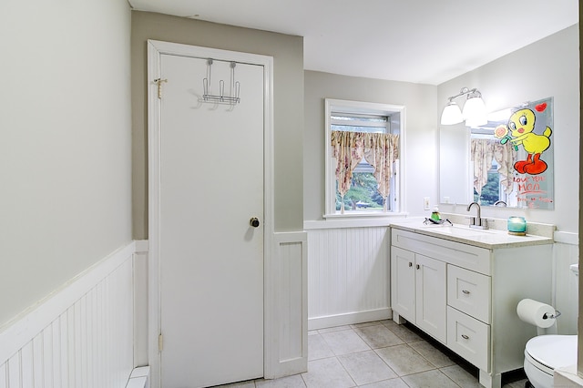 bathroom with toilet, tile patterned floors, and vanity