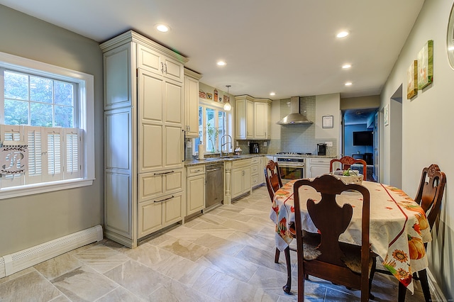 kitchen with appliances with stainless steel finishes, a baseboard heating unit, wall chimney range hood, decorative light fixtures, and backsplash