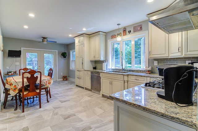 kitchen with light stone countertops, stainless steel dishwasher, island range hood, sink, and pendant lighting