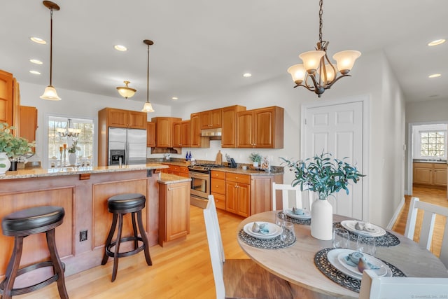 kitchen with stainless steel appliances, decorative light fixtures, and a notable chandelier