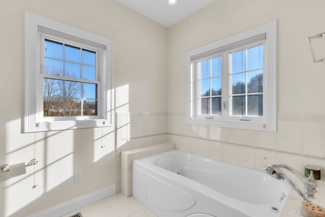 bathroom featuring tile patterned flooring, a bathtub, and a wealth of natural light