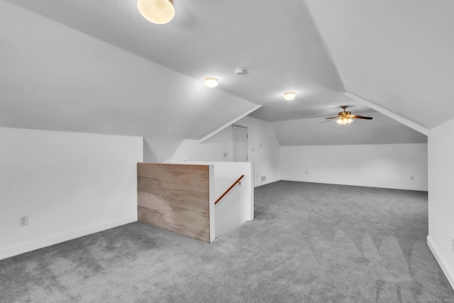 additional living space featuring lofted ceiling and dark carpet