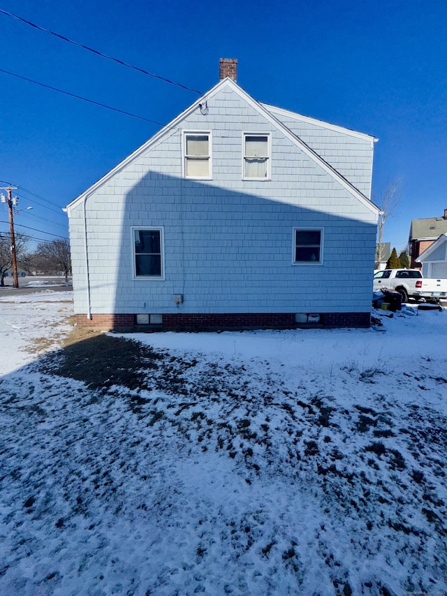 view of snow covered rear of property