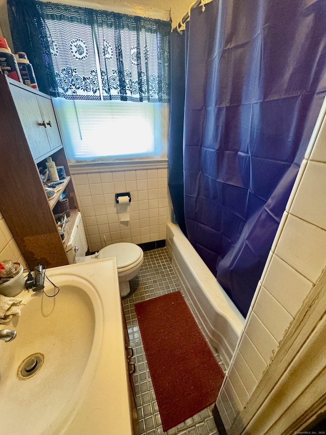 full bathroom with tile patterned floors, toilet, sink, tile walls, and shower / bath combo with shower curtain