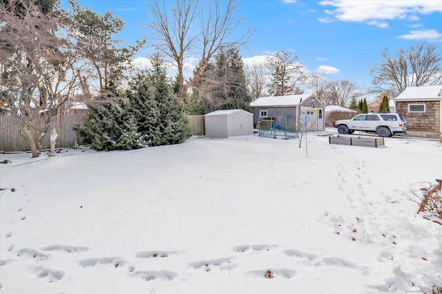 yard layered in snow with a storage shed