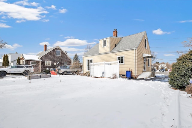 view of snow covered back of property