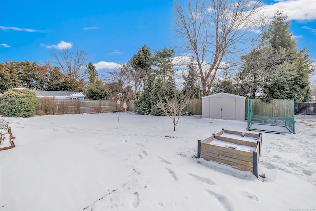 yard layered in snow with a shed