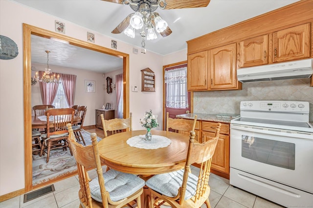 kitchen featuring tasteful backsplash, a healthy amount of sunlight, light tile patterned floors, and white range with electric stovetop