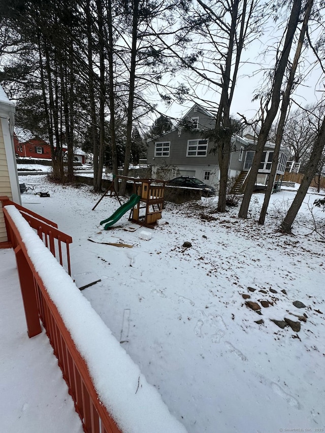 yard layered in snow with a playground