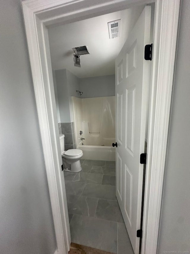 bathroom with bathtub / shower combination and toilet