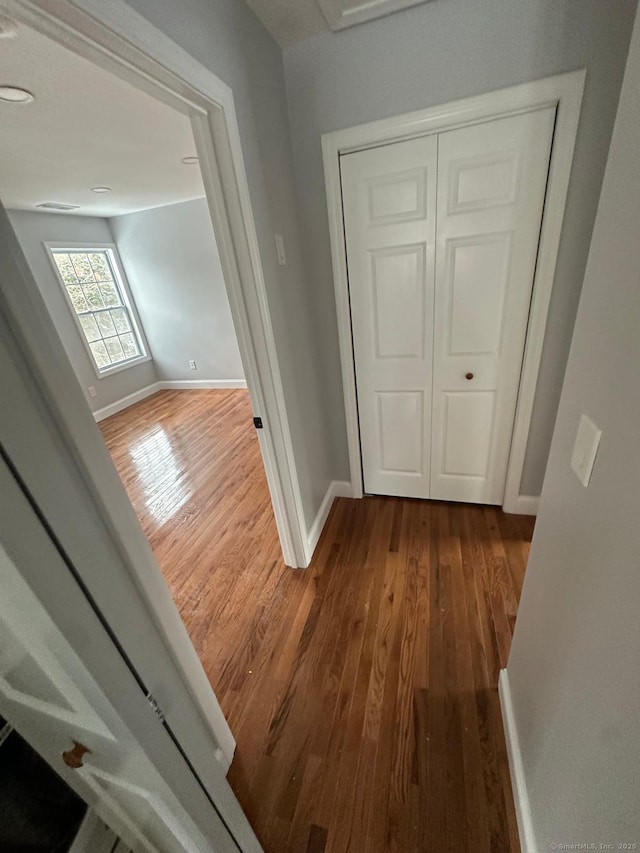 hallway with hardwood / wood-style flooring