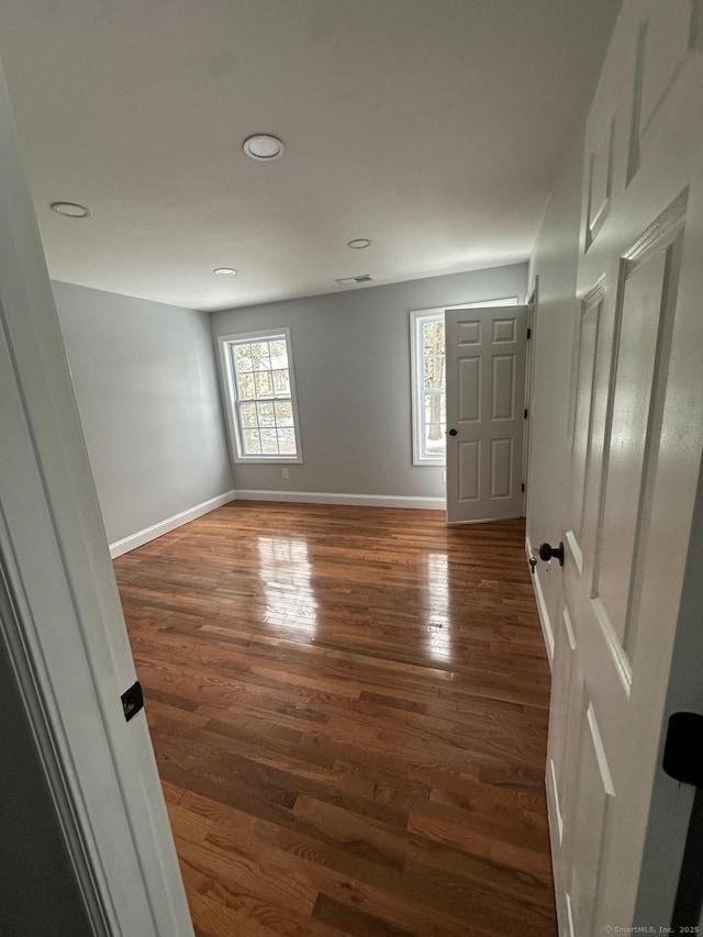 empty room with dark hardwood / wood-style flooring