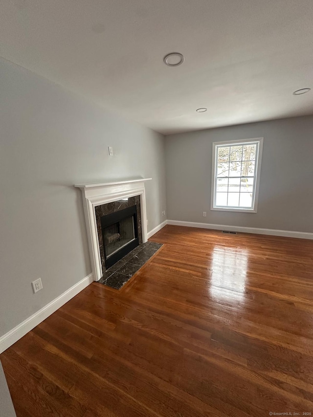 unfurnished living room with dark hardwood / wood-style flooring and a fireplace