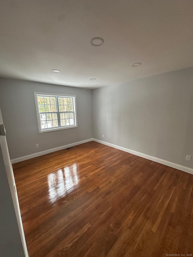 spare room with dark hardwood / wood-style flooring