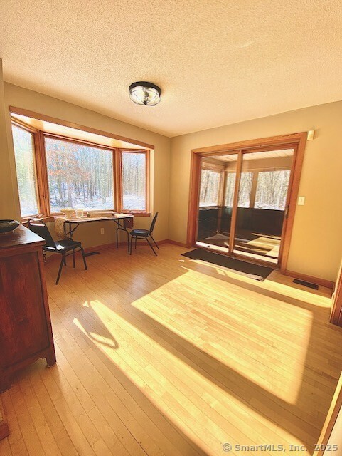 interior space with light hardwood / wood-style floors and a textured ceiling