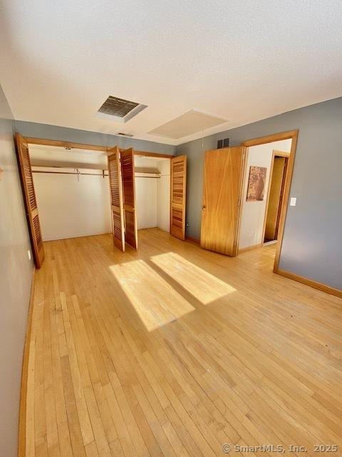 unfurnished bedroom with a textured ceiling, light hardwood / wood-style flooring, and a closet