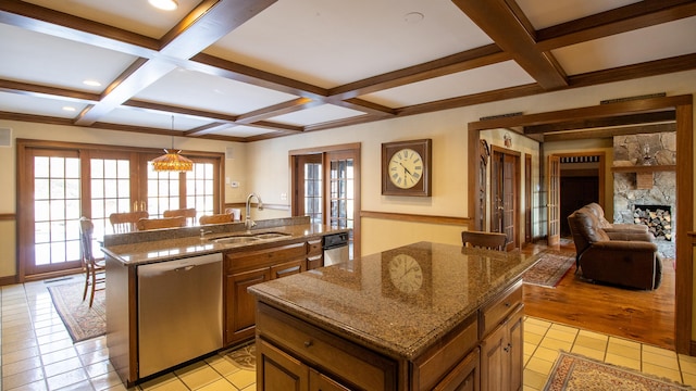 kitchen featuring an island with sink, sink, stainless steel dishwasher, and french doors