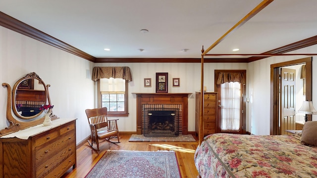 bedroom featuring ornamental molding, a brick fireplace, and light wood-type flooring