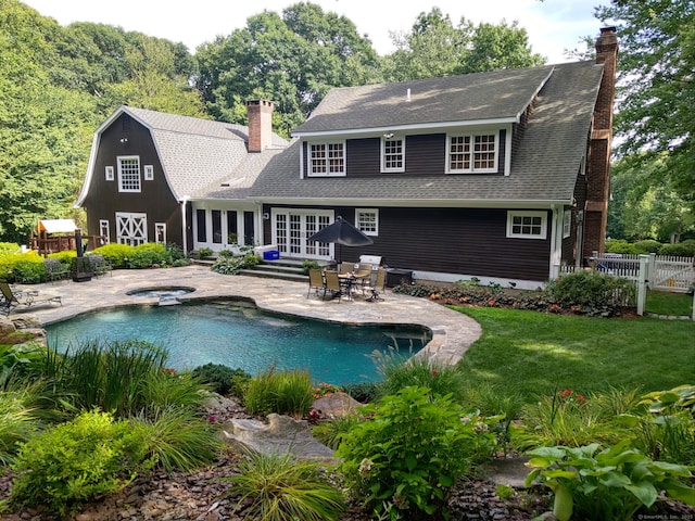 back of property with a patio, a yard, and french doors