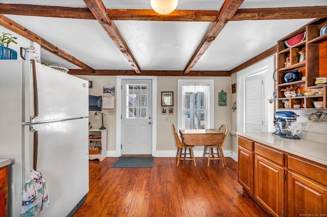 kitchen featuring beam ceiling, dark hardwood / wood-style floors, and white fridge