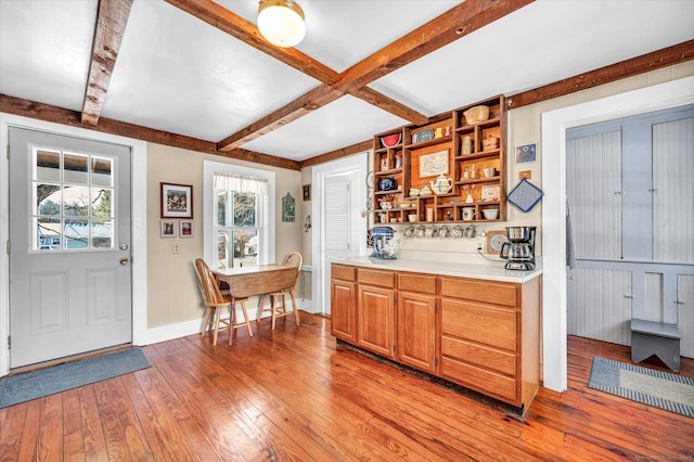 kitchen featuring beamed ceiling, coffered ceiling, and light hardwood / wood-style flooring