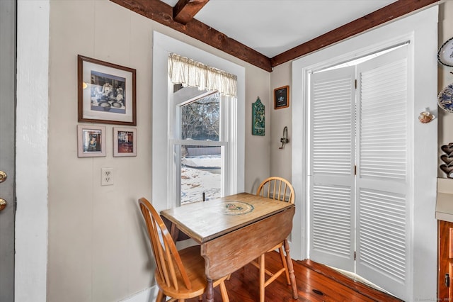 dining space featuring hardwood / wood-style flooring and beamed ceiling