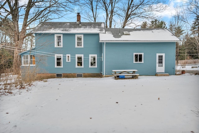 view of snow covered rear of property