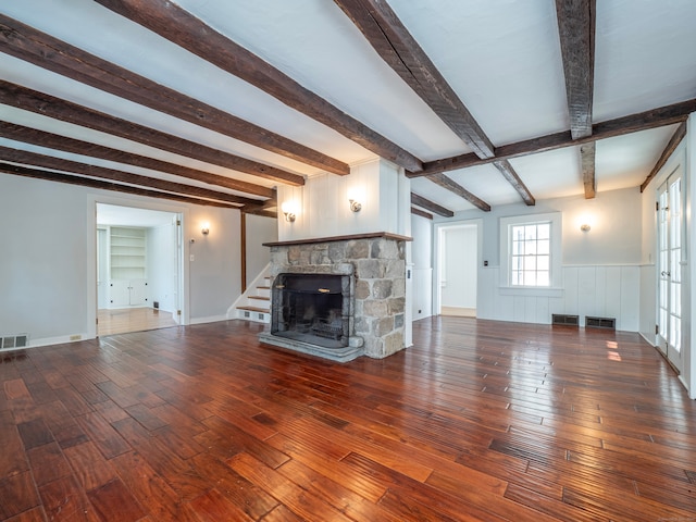 unfurnished living room with hardwood / wood-style flooring, a fireplace, and beamed ceiling