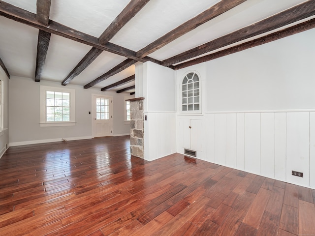 unfurnished living room with dark hardwood / wood-style floors and beam ceiling