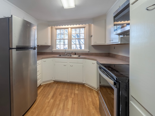 kitchen with light wood-type flooring, stainless steel appliances, sink, and white cabinets