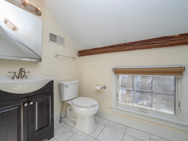 bathroom featuring vanity, toilet, and vaulted ceiling