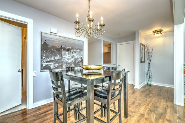 dining space featuring dark hardwood / wood-style floors and an inviting chandelier