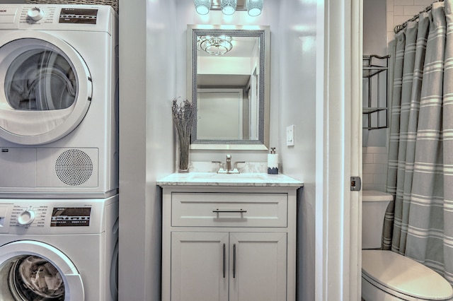 washroom with sink and stacked washer / drying machine