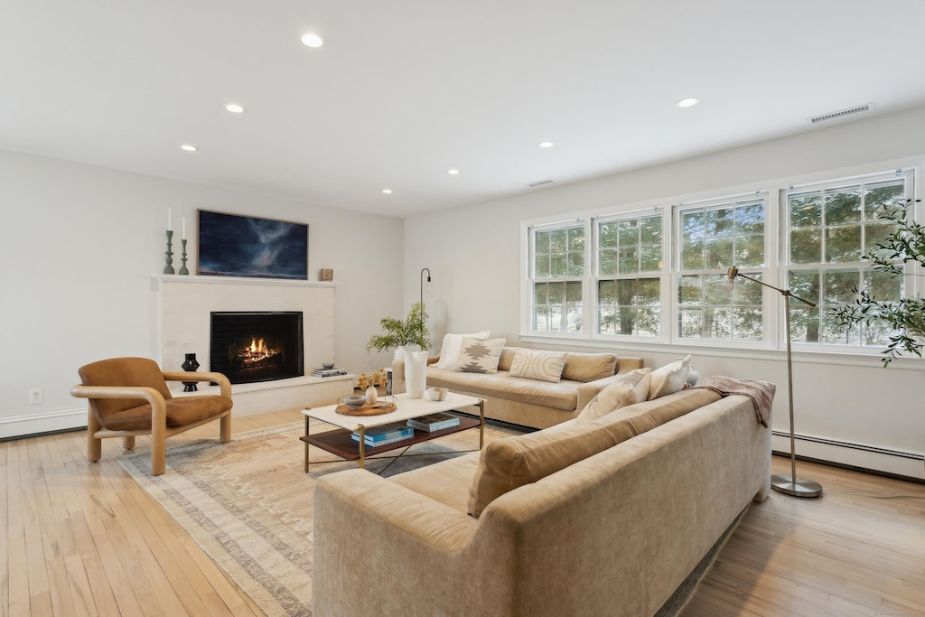 living room featuring light hardwood / wood-style flooring and a baseboard heating unit