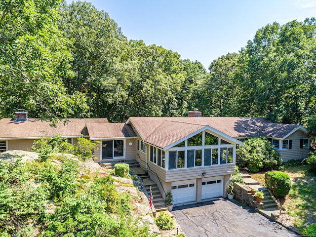 view of front of home with a garage and a sunroom