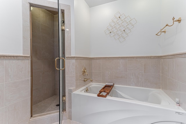 bathroom featuring separate shower and tub and tile walls