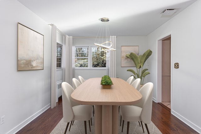 dining area with an inviting chandelier and dark hardwood / wood-style floors