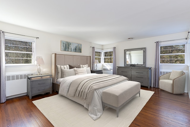 bedroom featuring radiator heating unit and dark wood-type flooring