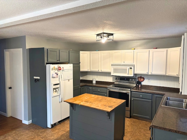 kitchen with gray cabinets, butcher block counters, white cabinets, and white appliances