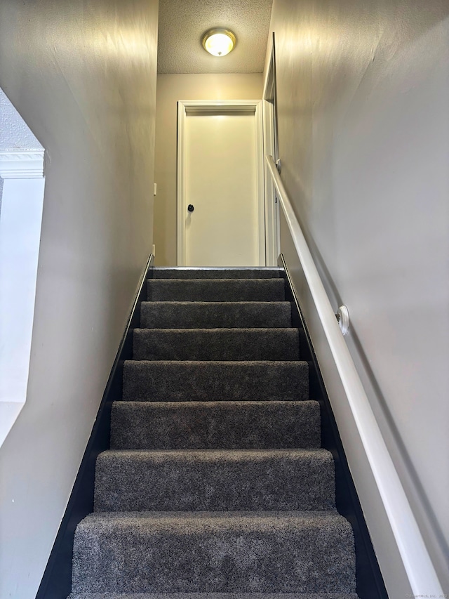 stairway with a textured ceiling