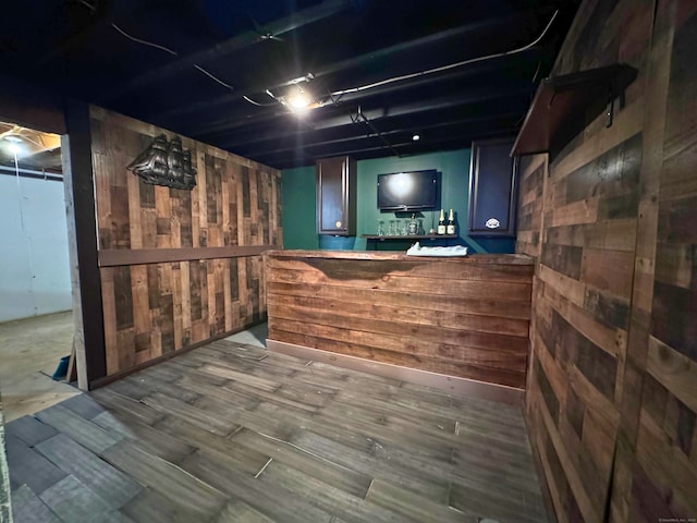 bar featuring hardwood / wood-style floors and wood walls