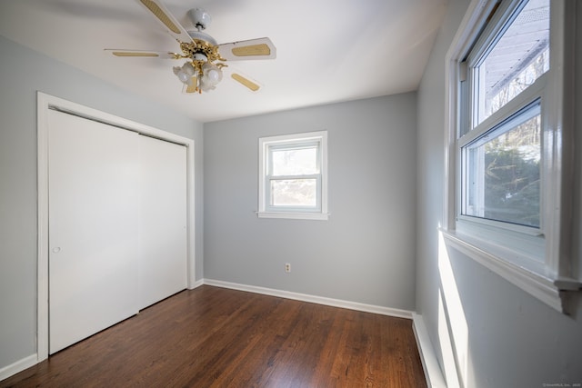 unfurnished bedroom featuring dark hardwood / wood-style flooring, ceiling fan, and a closet